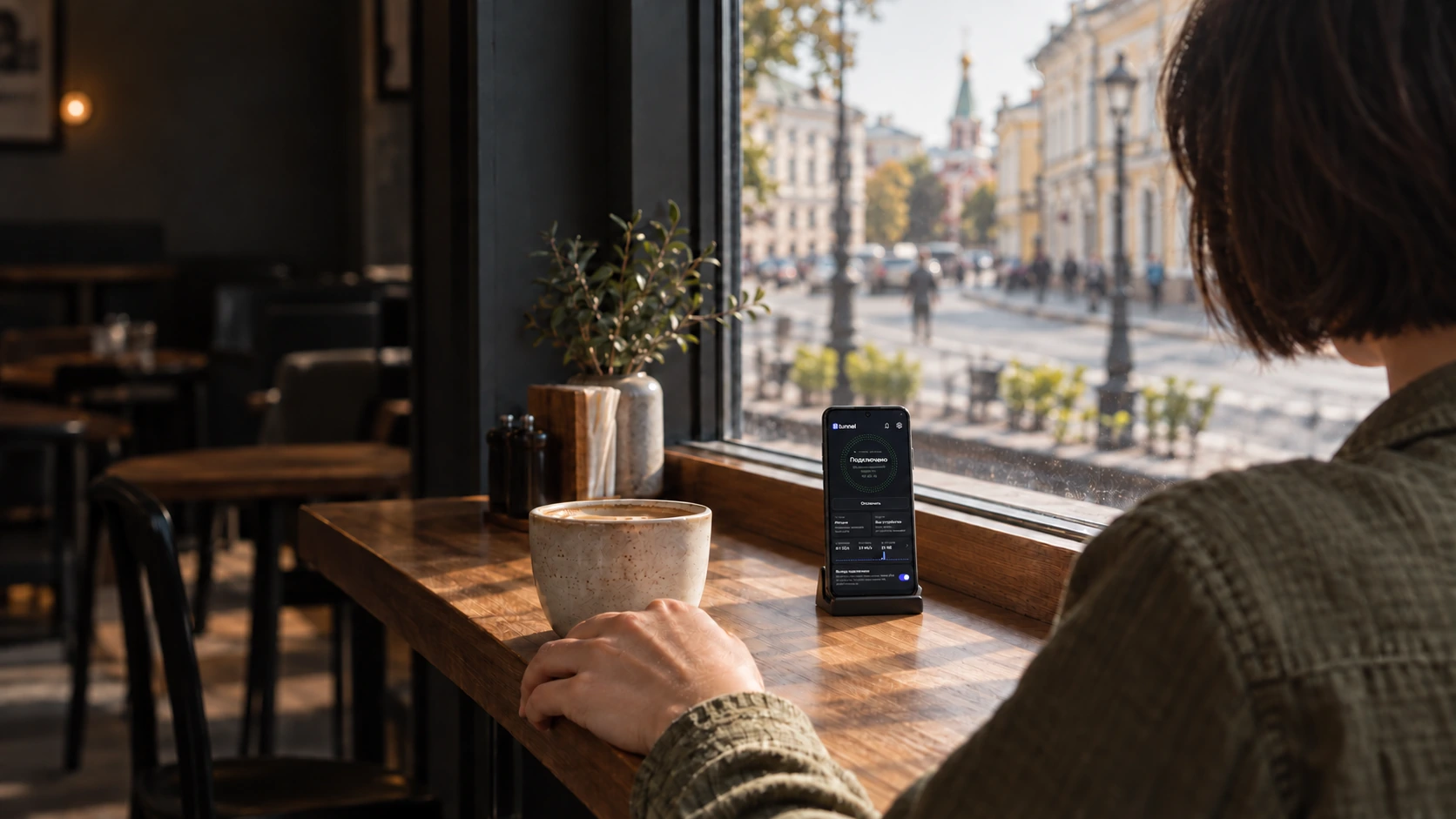 Женщина за столом в кафе смотрит на Android-смартфон с примером интерфейса 8Tunnel.